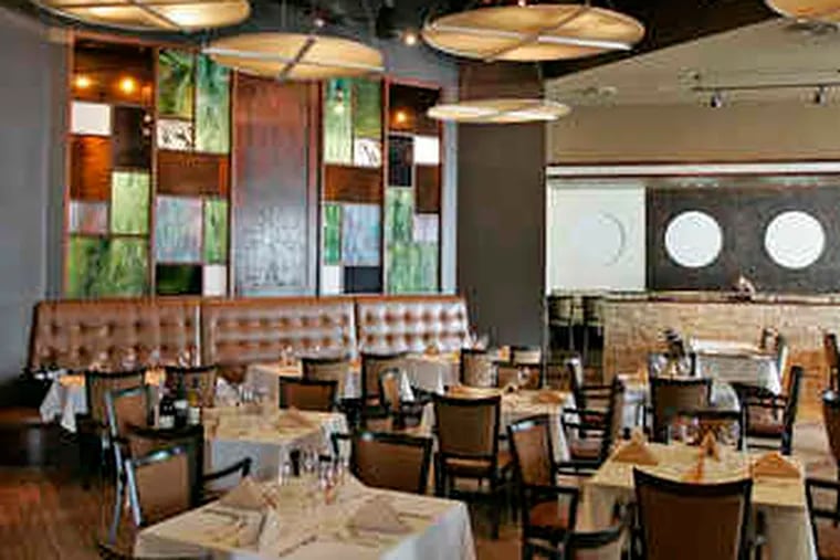 The main dining room of Parker's Prime in Newtown Square with a modern, open layout and, above, a semi-private semicircular table, cozy and isolated in the public space.