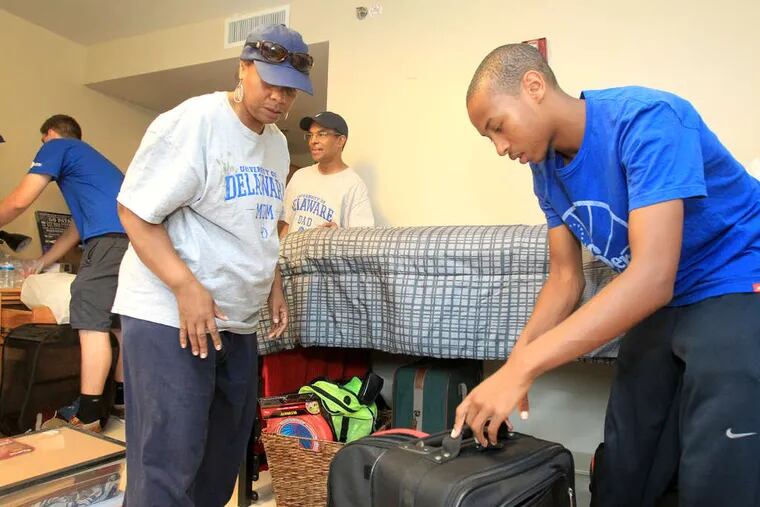 Aaron Lankford unpacks with help from his mother, Debra Johnson-Lankford, and father, Estel Lankford. Lankford is one of about 60 University of Delaware freshmen who volunteered to triple up.