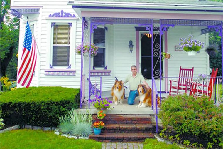 Eric Reisman on the front porch of his 1910 house in Ambler with his dogs, Deco and Athena. He bought the house in 1987. (Ron Tarver / Staff photographer)