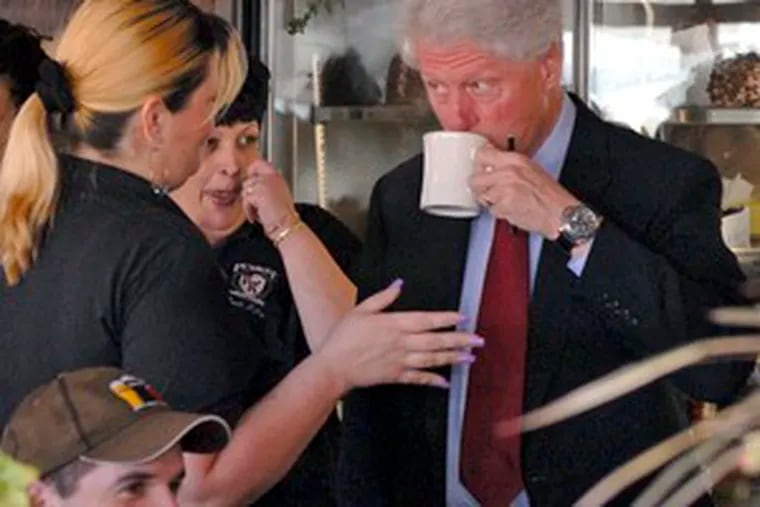Bill Clinton sips coffee and chats with server Susan Borman (left) at the Penrose Diner while campaigning for his wife, presidential candidate Hillary Rodham Clinton.