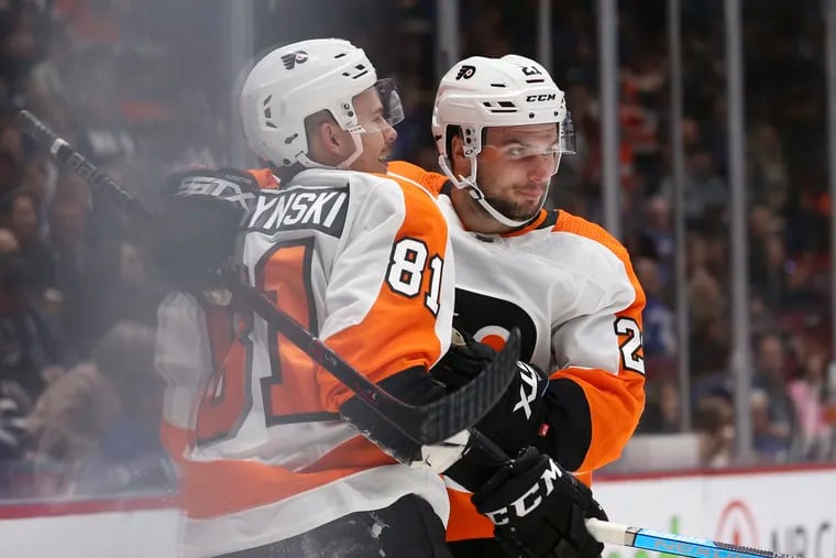 Flyers right winger Carsen Twarynski (81) celebrates his first career NHL goal with Scott Laughton (21) during the second period of their 3-2 shootout loss Saturday in Vancouver.