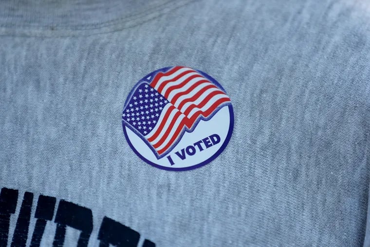 A voter wears a sticker outside the polling station on Election Day at the West Chester Library in West Chester, Pa. on Tuesday, May 17, 2022.