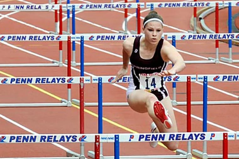 Kelly Curtis, from Springfield College, clears a hurdle during a 100-meter heat at Franklin Field. (Clem Murray/Staff Photographer)
