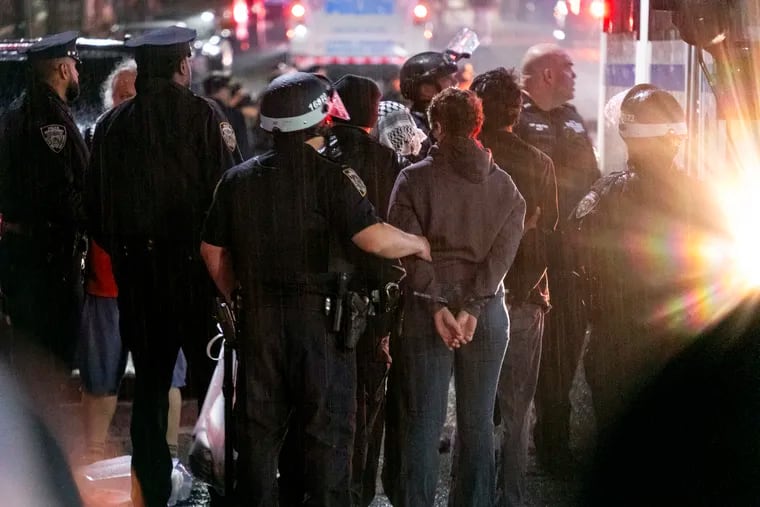 New York City police officers take people into custody near the Columbia University campus in New York on Tuesday, April 30, 2024, after a building taken over by protesters earlier in the day was cleared, along with a tent encampment.