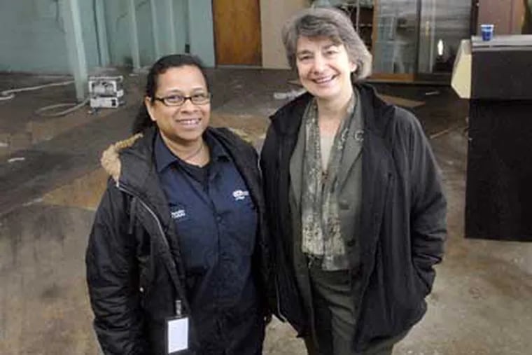 Suechada Poynter (left), who earns $11 an hour as a home-energy auditor, is joined by Liz Robinson of the Energy Coordinating Agency at a former factory where green-job skills will be taught. (April Saul / Staff Photographer)