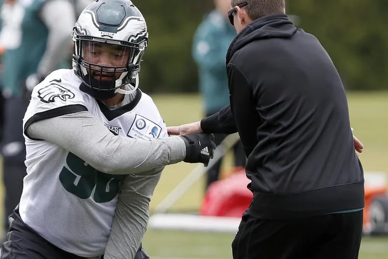The Eagles’ Derek Barnett (left) works with coach Dave Fipp during rookie camp.