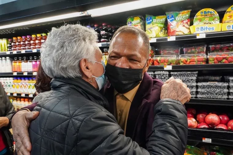 José Gómez embraces a customer at the grand opening of Juniata Supermarket's second store in North Philadelphia, on December 1, 2021.