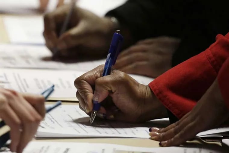 A too-familiar scene still: Applicants filling out forms at a jobs fair in Newark, N.J. (Mark Lenninhan / Associated Press)