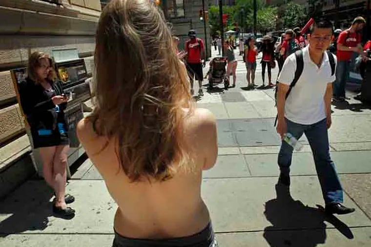 An unidentified male walks past Moira Johnston of suburban Philadelphia as she stands bared breasted along Walnut St. and 18th St in the Rittenhouse section of Philadelphia on June 4, 2013. She says she is making a statement about the sexualization of the female body. ( ALEJANDRO A. ALVAREZ / STAFF PHOTOGRAPHER )