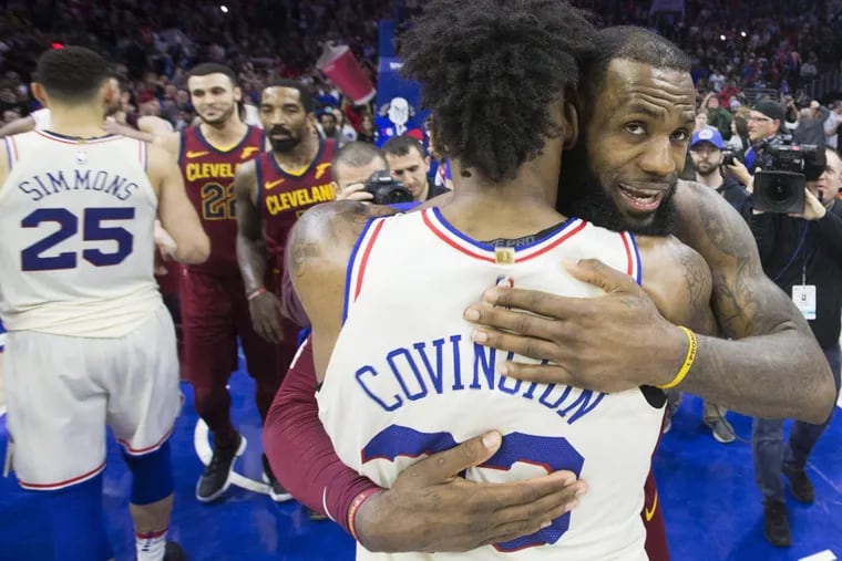 LeBron James, right, of the Cavaliers hugs Robert Covington of the Sixers after their game at the Wells Fargo Center on April 6, 2018.