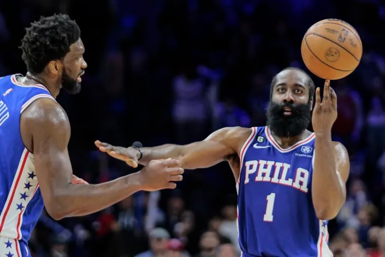 Sixers James Harden tries to keep Joel Embiid away while he spins the ball on his finger as the clock winds down against the Pelicans on Monday night.