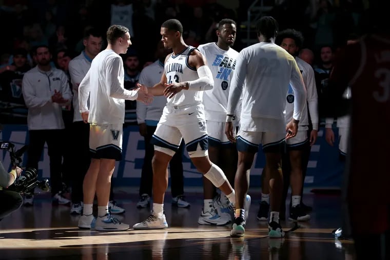 Eric Dixon, center, of Villanova slaps hands with Kevin Voigt as he is introduced as part of the starting lineup against Ohio State  in the NCAA Tournament on March 20, 2022 at PPG Arena in Pittsburgh, PA.