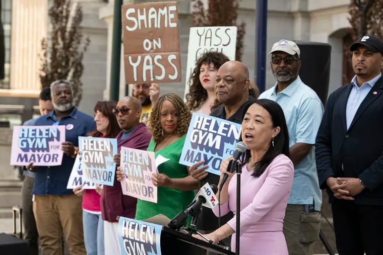 Helen Gym (center) gathers with progressive City Council candidates, elected officials, and community leaders to denounce conservative billionaire Jeffrey Yass and his allies at a rally Monday at City Hall.