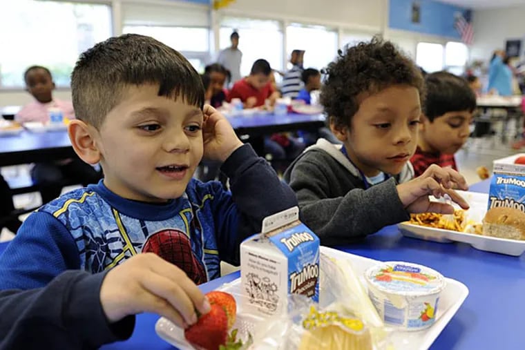 A national effort to help kids eat healthy and be a healthy weight is splintering in a food fight embroiling Congress, health professionals, the White House, and even cafeteria workers. Here, students in a Virginia school eat in the school cafeteria. (File photo)