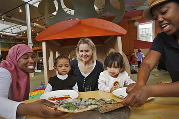 From left: Rachel Azzaam, prepares to serve daughter Fatimah Morisseau, 2, a slice of pizza at The Little Green Treehouse. Center is owner Rachael Williams, with Tallulah Green-Hull, 2, being served a slice of pizza by her mother, Amanda Green-Hull. (ALEJANDRO A. ALVAREZ / Staff Photographer)
