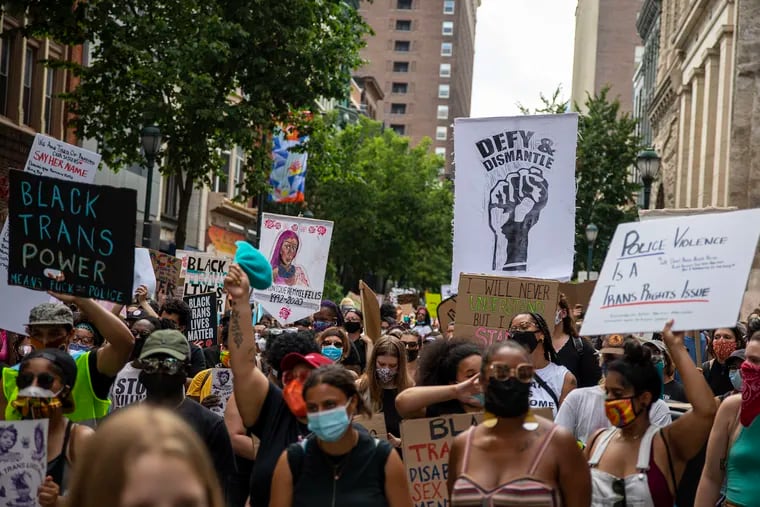 Protesters march toward Independence Hall holding banners in support of Black Trans Lives Matter on Saturday.