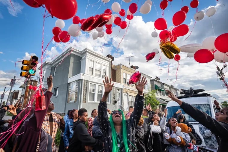 Shanae Thomas (center), mother of Jaseem Thomas, at a balloon release and vigil for her son, in Southwest Philadelphia on Friday.