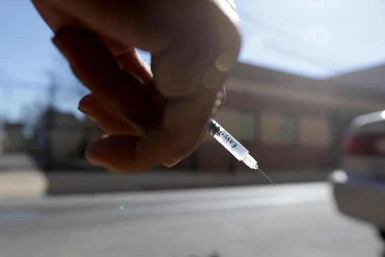A heroin user who didn’t want to be identified holds a needle on the 1800 block of Hilton Street in Philadelphia. It is a possible site for a supervised injection facility.