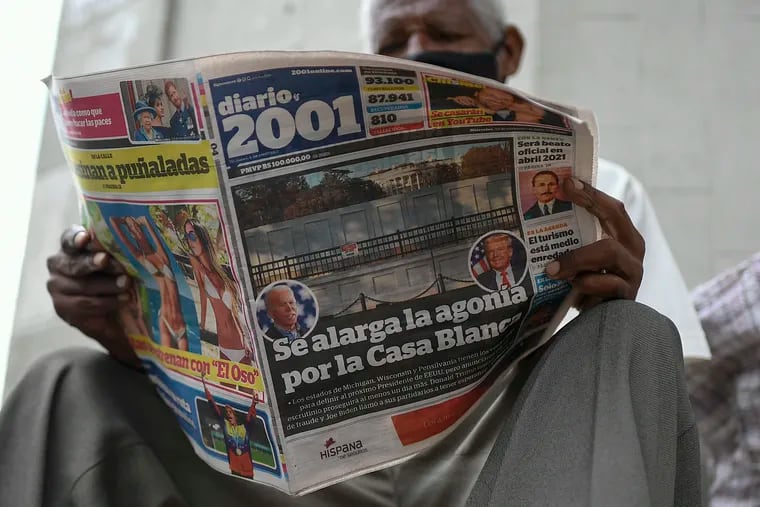 FILE - In this Nov. 4, 2020, a man reads the Diario 2001 newspaper that carries the Spanish headline: "Agony is prolonged for the White House" at a newspaper stand in Caracas, Venezuela, the day after U.S. elections. Across the world, many were scratching their heads Friday wondering if those assertions could truly be coming from the president of the United States, the nation considered one of the world’s most emblematic democracies.