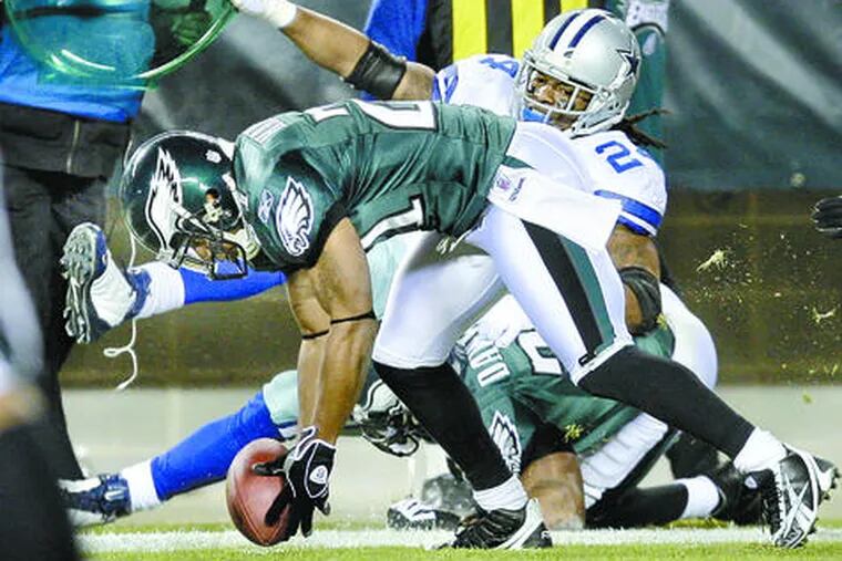 The Eagles&#0039; Joselio Hanson picks up a fumble after Brian Dawkins knocked the football away from Dallas running back Marion Barber.