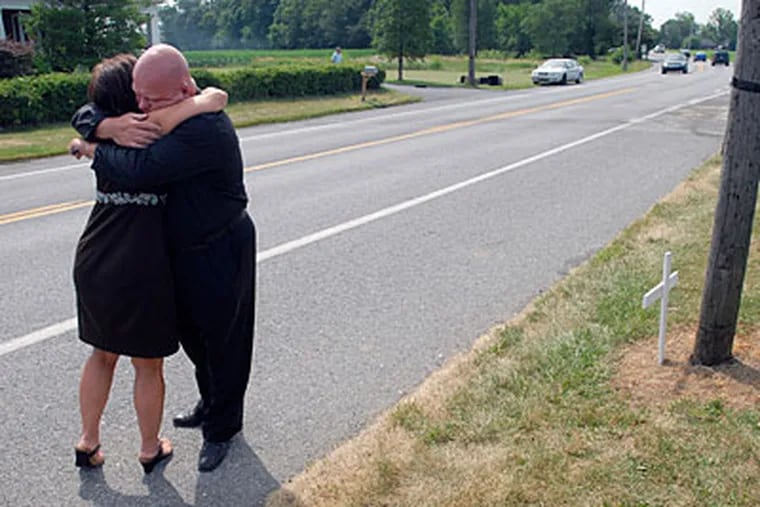 Gregg Specht and Darlene Black, friends of accident victims, hug next to Pennsylvania Route 72 north of Graystone Road, south of Manheim, Pa. (AP Photo/Lancaster Newspapers, Dan Marschka)