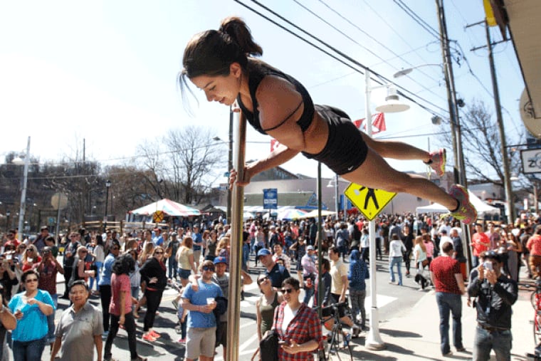 Rocio Sanchez, of the Awakenings Pole Dance Fitness company, performs high over the crowd on Main Street Sunday afternoon at the bi-annual Manayunk Food Festival.