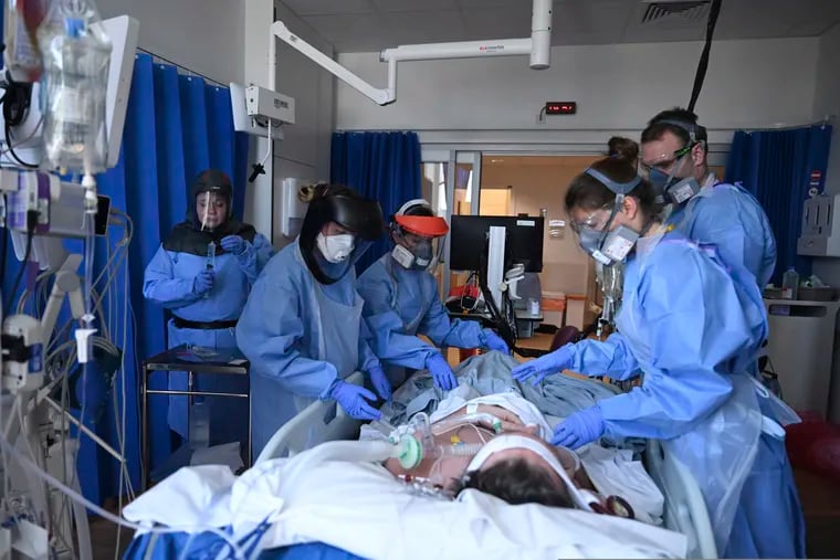 Members of the clinical staff wearing Personal Protective Equipment PPE care for a patient with coronavirus in the intensive care unit at the Royal Papworth Hospital in Cambridge, England.