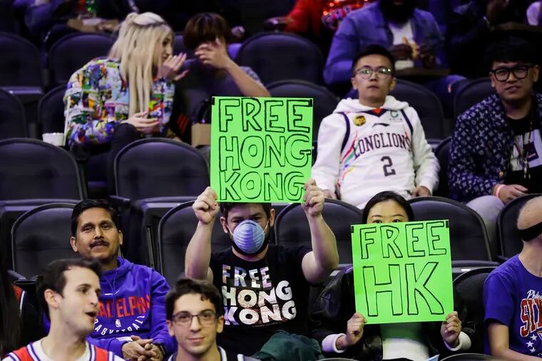 Fans hold signs ahead of a an NBA exhibition basketball game between the Philadelphia 76ers and the Guangzhou Loong-Lions on Tuesday, Oct. 8, 2019, in Philadelphia.