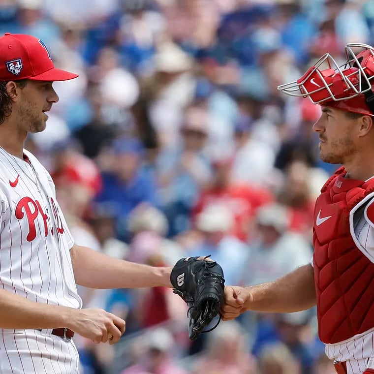 Phillies starting pitcher Aaron Nola touches catcher J.T. Realmuto’s glove before Nola got replaced in the sixth inning.