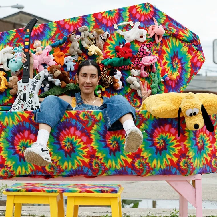 South Philly artist Rose Luardo sits in her latest guerrilla art project, the tie-dye "Rave Coffin," at the triangular cement lot between Washington Avenue, Passyunk Avenue, and Eighth Street in South Philly.