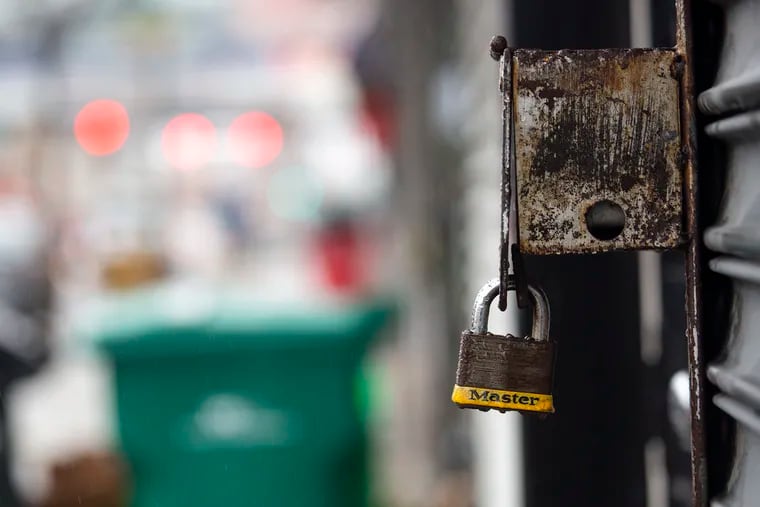 A Master lock on a gate is seen along 52nd Street where local businesses have temporarily closed due to the coronavirus outbreak on Saturday, March, 28, 2020.