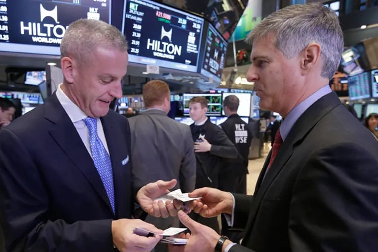 Aramark President and CEO Eric Foss, left, and Hilton Worldwide CEO Christopher Nassetta, exchange business cards after both companys' IPOs began trading on the floor of the New York Stock Exchange, Thursday, Dec. 12, 2013.  (AP Photo/Richard Drew)