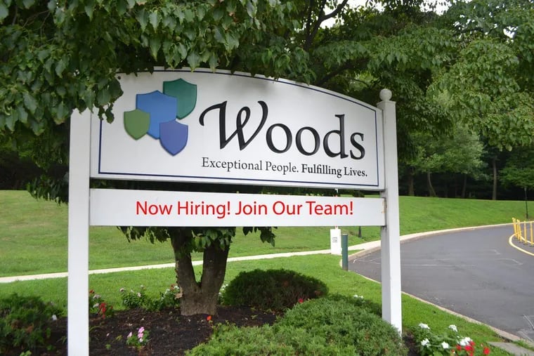 A sign at one of Woods Services’ entrances at its campus near Langhorne.