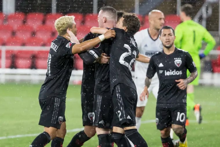 Wayne Rooney celebrates with D.C. United teamates after scoring the game-winning penalty kick against the Union.