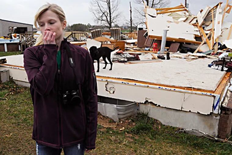 Lindsey Kidd reacts after viewing the rubble of her boyfriend's parents' home outside Puxico, Mo., where one person was reported killed in a storm Wednesday. The country-music mecca of Branson was also hit hard, with 37 injuries reported. (Paul Davis / Associated Press)
