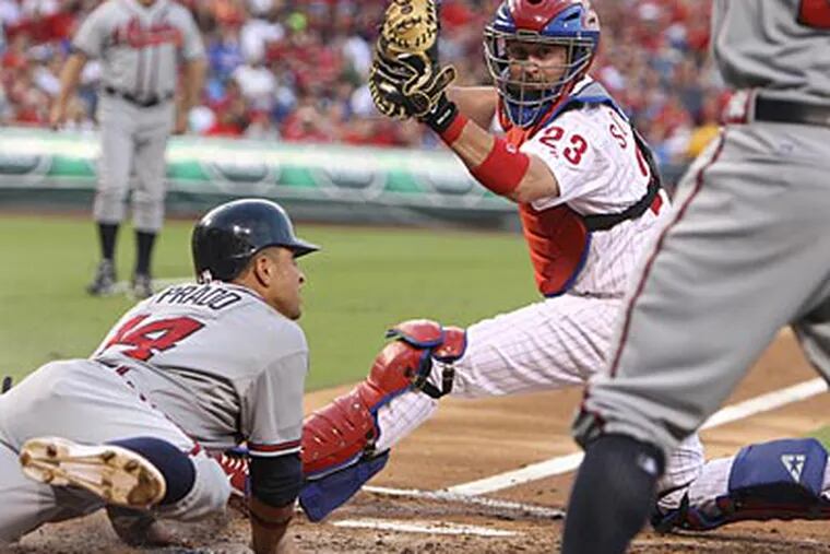 Martin Prado gets under the tag of Phillies catcher Brian Schneider in the third inning on Monday. (Ron Cortes/Staff Photographer)