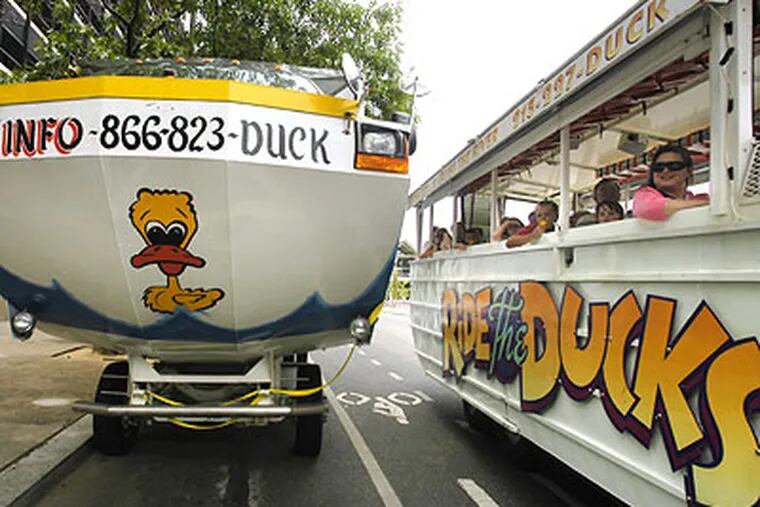 Left: A Super Ducks vehicle/craft travels on 6th Street between Market and Chestnut Streets. Right: A Ride the Ducks vehicle passes by, about to park. (Staff File Photo)