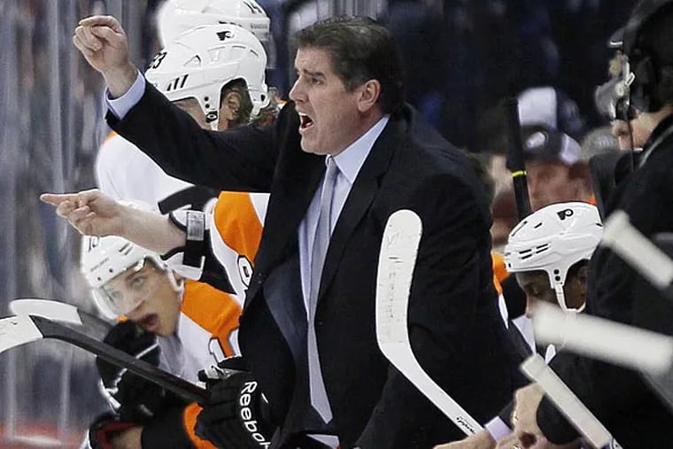 Philadelphia Flyers head coach Peter Laviolette yells to his players during the second period of their NHL game against the Winnipeg Jets in Winnipeg on Saturday, April 6, 2013. (AP Photo/The Canadian Press, John Woods)