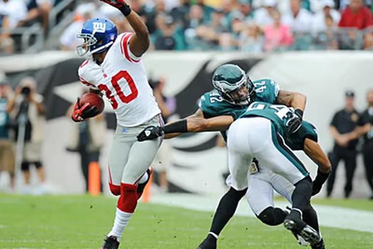 Nnamdi Asomugha and Kurt Coleman collide as they try to tackle the Giants' Victor Cruz. (Clem Murray/Staff Photographer)