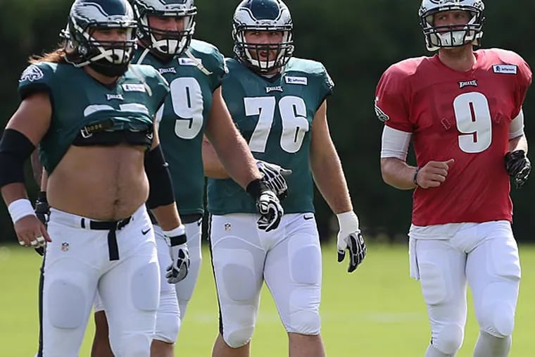 Eagles' Nick Foles (right) jogs back with Jason Kelce, left, Todd Herremans and Allen Barbe during Eagles practice. (David Maialetti/Staff Photographer)