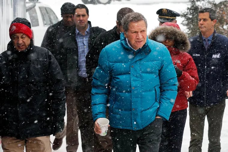 Snow falls as Republican presidential candidate John Kasich arrives for a campaign stop to discuss alcohol and drug-free programs for the youth Monday, Jan. 18, 2016, in Plymouth, N.H.