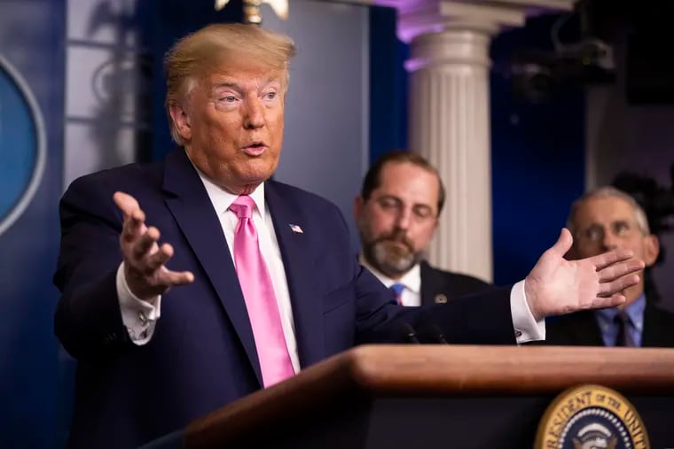 President Donald Trump with Department of Health and Human Services Secretary Alex Azar, back center, and Director of the National Institute of Allergy and Infectious Diseases at the National Institutes of Health Anthony Fauci, right, during a news conference at the White House on Feb. 26, 2020.