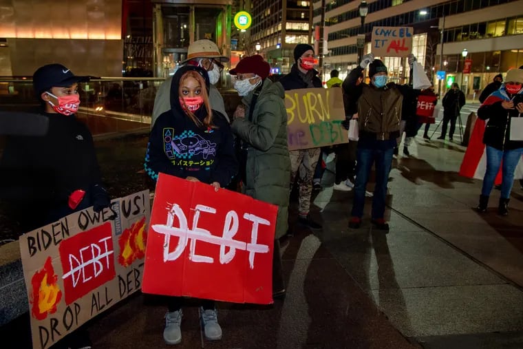 Community organizations protest and rally near Joe Biden Headquarters at 15th and Market Streets Jan. 4, 2021, demanding the president-elect cancel student debt. Speakers chanted "Biden owes Philly" and, after writing the amount of their own debt on a small sheet of paper, ignited it with candles and burned it in a symbolic action.