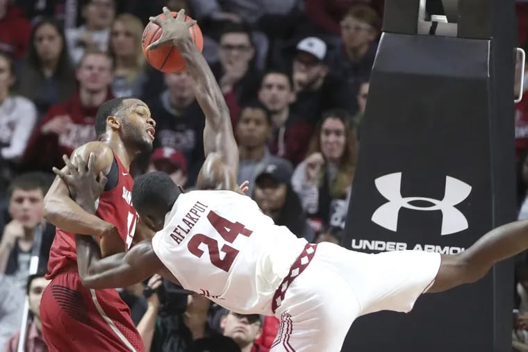 Chris Clover of St. Joseph's fouls Ernest Aflakpui of Temple to prevent a layup during 2nd half action at the Liacouras Center on Dec. 9, 2017. CHARLES FOX / Staff Photographer