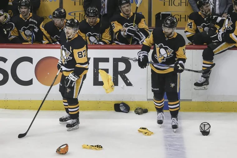 Sidney Crosby (left) watched as hats were thrown on the ice after his third goal in Pittsburgh’s 7-0 Game 1 win Wednesday.
