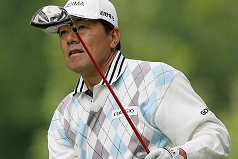 Kiyoshi Murota watches his tee shot on the second hole on Friday. (Ed Reinke/AP Photo)