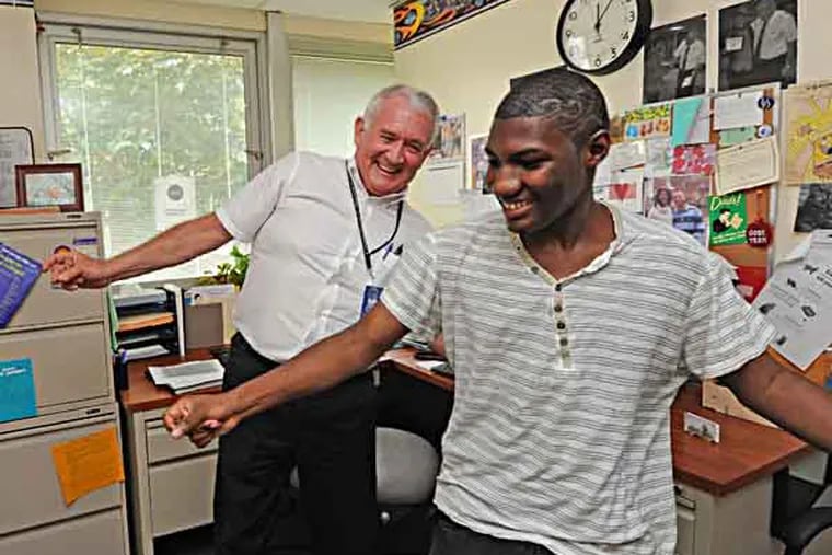At Collingswood High School, guidance counselor Dennis Gaughn goes above and beyond his job description to help kids, photos taken on 5/21/13. Here, he dances with Faison Sanders, 16, who routinely comes to Gaughn's office to teach him moves and use Gaughn's cologne.  ( APRIL SAUL / Staff )
