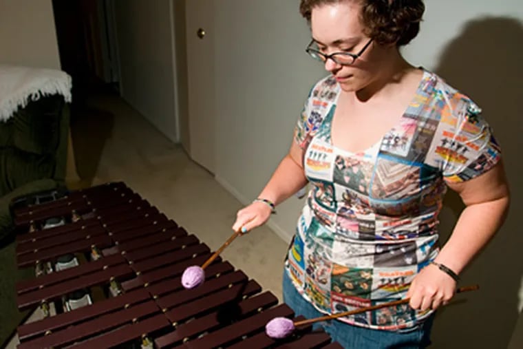 Kristin D'Antonio, 20, plays the marimba in her East Norriton apartment. D'Antonio is slowly going deaf from a neurological disease. (KRISTON J. BETHEL / Staff photographer)