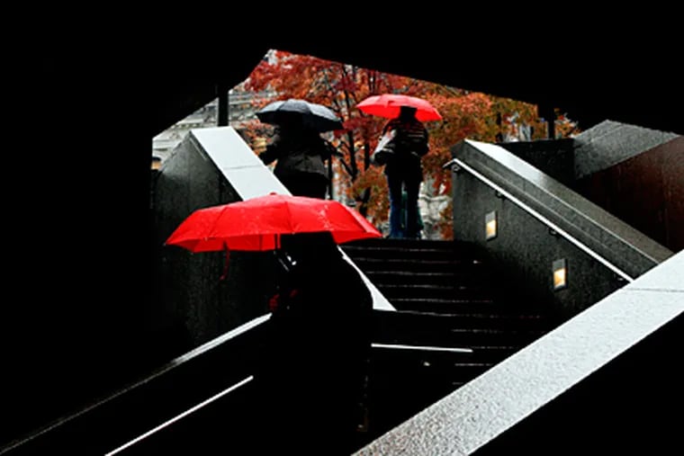 SEPTA commuters come and go at 15th Street and JFK in the rain Wednesday, which made 2011 Philadelphia's wettest year ever. (Michael S. Wirtz / Staff Photographer)