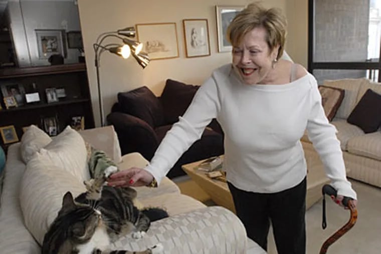 Susan Chernin at home in Society Hill with Max, one of her cats. She lost thousands of dollars' worth of items to thieves. (APRIL SAUL / Staff Photographer)